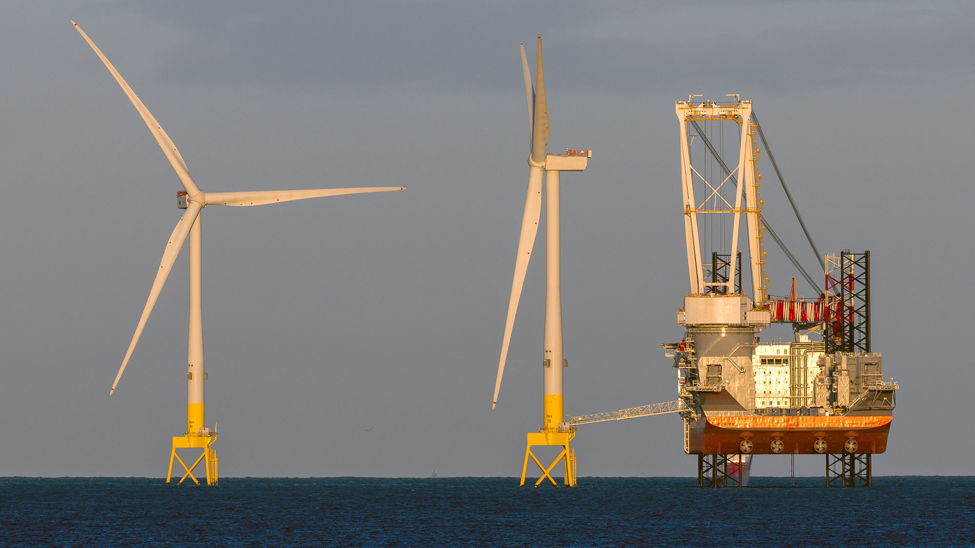 offshore wind farm installation vessel next to a wind turbine 